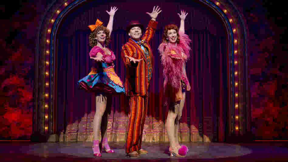 Danny Burstein, as Buddy Plummer, performs "Buddy's Blues," the high-energy song-and-dance number at the end of Follies, with Jenifer Foote (left) and Kiira Schmidt. Danny Burstein, as Buddy Plummer, performs "Buddy's Blues," the high-energy song-and-dance number at the end of Follies, with Jenifer Foote (left) and Kiira Schmidt.