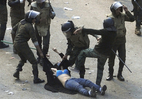 Egyptian army soldiers arrest a female protester during clashes at Tahrir Square in Cairo on Dec. 17.