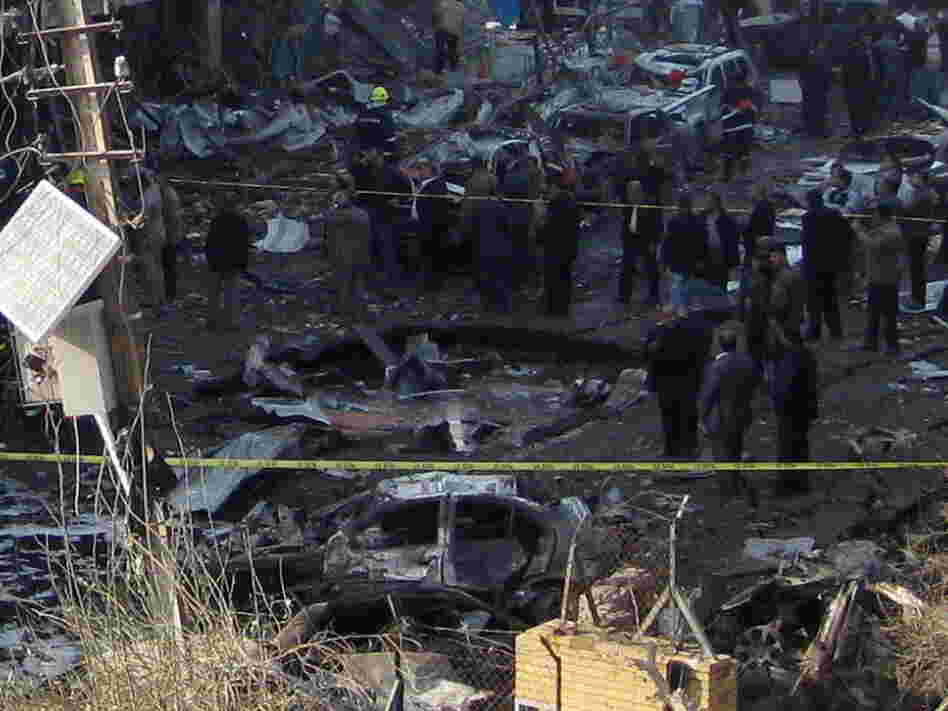 Iraqi security forces inspect a crater caused by a car bomb attack in the neighborhood of Karrada in Baghdad earlier today (Dec. 22, 2011). It was one in a wave of such bombings in the Iraqi capital today. 