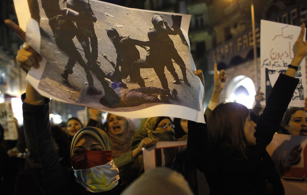 Angered by recent violence against them in clashes between army soldiers and protesters, Egyptian women — one carrying a poster with a picture of a woman who was assaulted by soldiers — chant anti-military slogans during a rally that ended in Cairo's Tahrir Square on Tuesday.