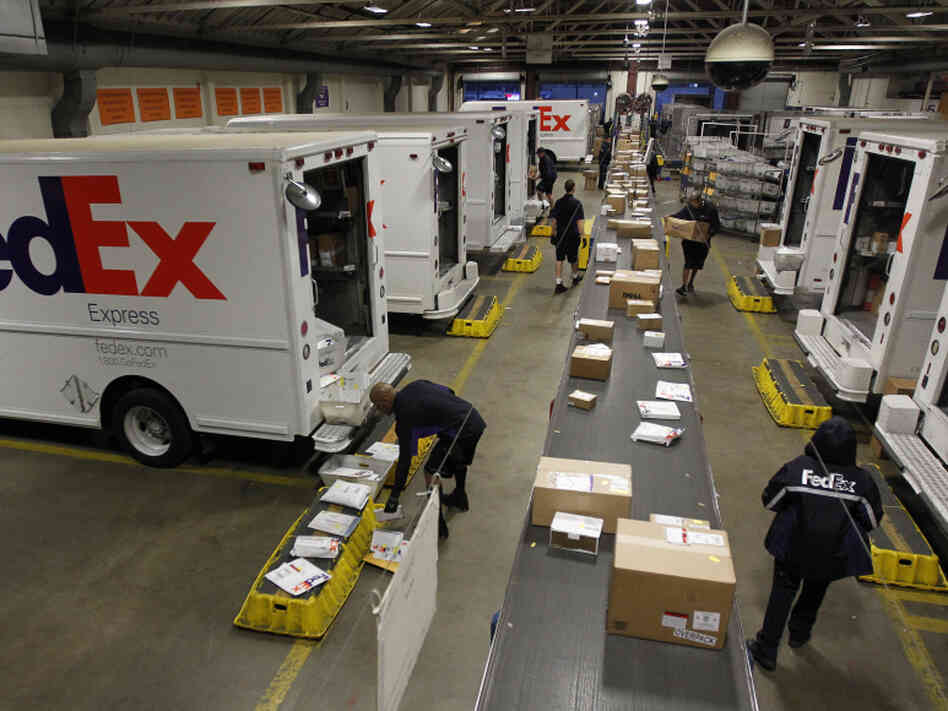 Couriers load packages onto vehicles as other packages move down the belt at the FedEx station in Marina del Rey, Calif. Online shopping made a big mark on FedEx's business this year, as more retailers are offering later-guaranteed arrivals than ever. Couriers load packages onto vehicles as other packages move down the belt at the FedEx station in Marina del Rey, Calif. Online shopping made a big mark on FedEx's business this year, as more retailers are offering later-guaranteed arrivals than ever.