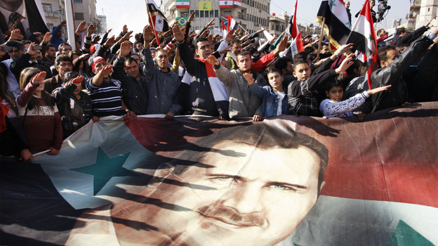 Critics of Syrian President Bashar Assad have been debating whether it would be better to threaten him with prosecution or encourage him to go into exile. Here, Syrians hold a rally supporting Assad in Damascus this month. Critics of Syrian President Bashar Assad have been debating whether it would be better to threaten him with prosecution or encourage him to go into exile. Here, Syrians hold a rally supporting Assad in Damascus this month.