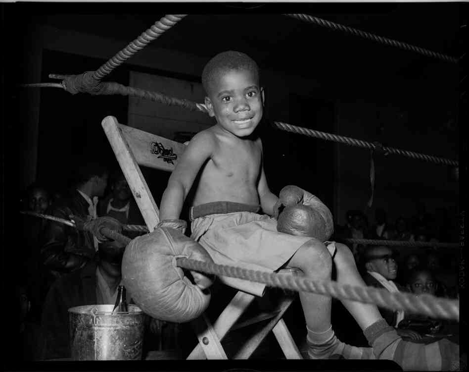 Little boy boxer, seated in boxing ring, possibly in Kay Boys' Club, circa 1945. Little boy boxer, seated in boxing ring, possibly in Kay Boys' Club, circa 1945.