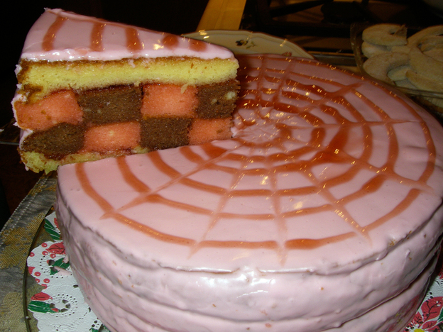 A punch torte: pink-glazed sponge cake with layers soaked in rum and citrus syrup.