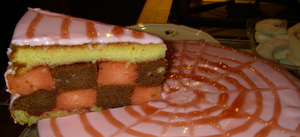 A punch torte: pink-glazed sponge cake with layers soaked in rum and citrus syrup.