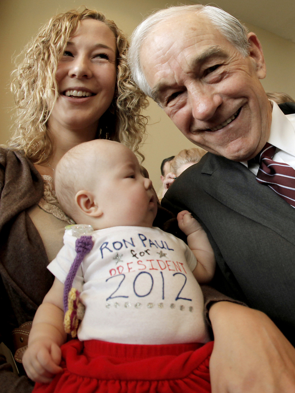 Rep. Ron Paul poses with a mother and her 3-month-old daughter in Dubuque, Iowa, Thursday, Dec. 22, 2011. 