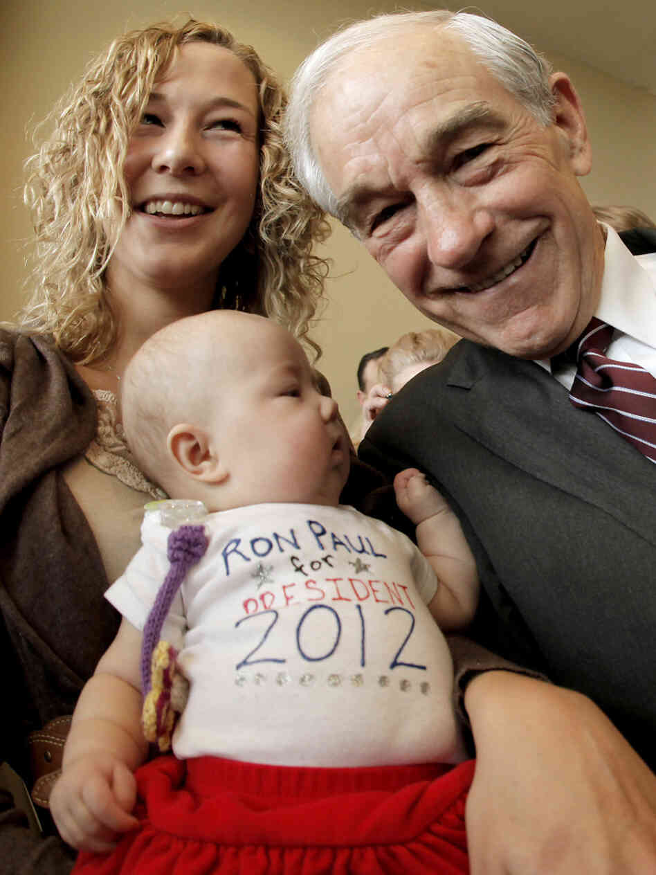 Rep. Ron Paul poses with a mother and her 3-month-old daughter in Dubuque, Iowa, Thursday, Dec. 22, 2011. 
