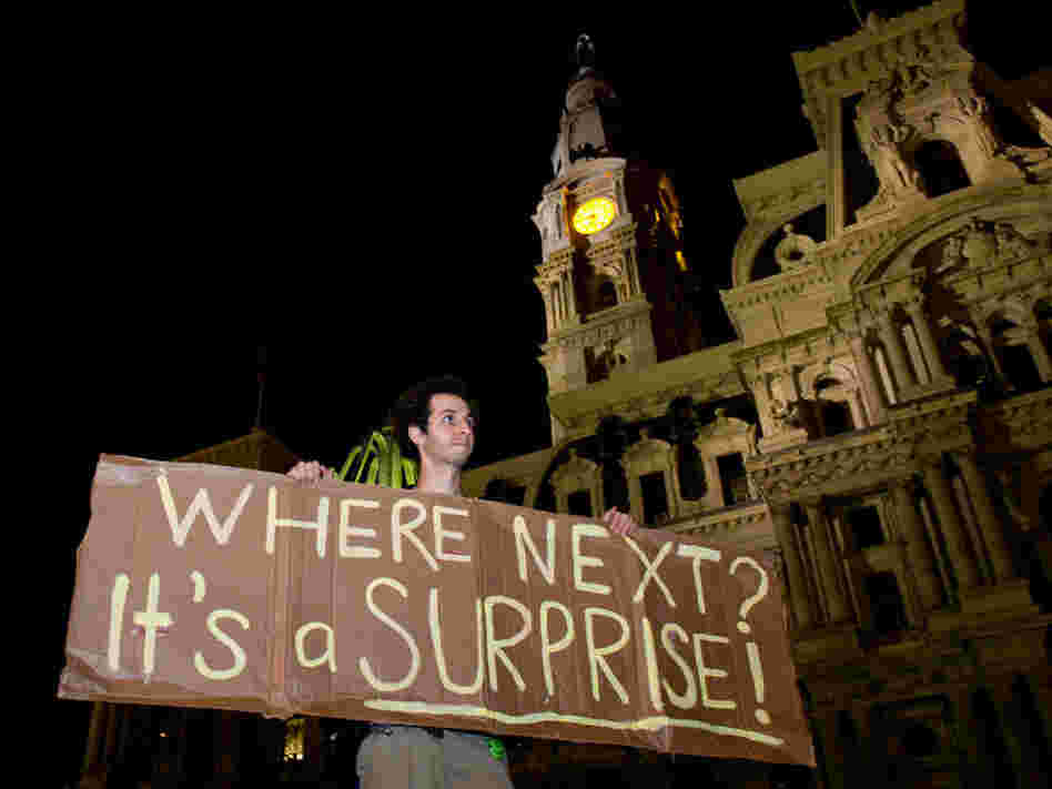 A protester holds a sign after a deadline to clear Occupy Philadelphia's Dilworth Plaza in late November. Occupy protesters across the country have found creative ways to continue their efforts after being evicted from public spaces.