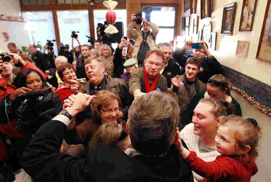 Republican Rick Perry (back to camera) greets supporters during a Dec. 27 campaign stop at the Main Street Cafe in Council Bluffs, Iowa. 