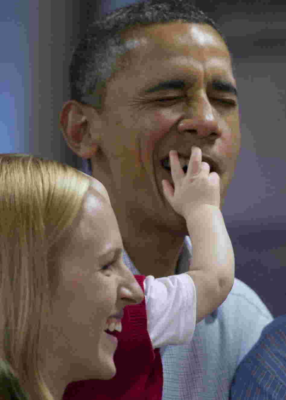 President Barack Obama got a mouth full of fingers from Cooper Wall Wagner, 8 months, as he posed for a photo with Cooper and his parents on Christmas Day in Hawaii. Mom, Meredith Wagner, is at left.Â 