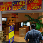 A shopper looks for bargains at an electronic store holding a going-out-of-business sale.