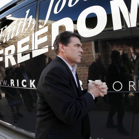 Texas Gov. Rick Perry walks to his bus after a campaign stop at the Glenn Miller Museum in Clarinda, Iowa on Dec. 27.