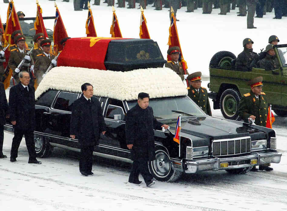 The heir apparent in North Korea, Kim Jong Un, in black at the front of the vehicle, walks besides the hearse carrying the body of his father and late leader Kim Jong Il at Kumsusan Memorial Palace. 