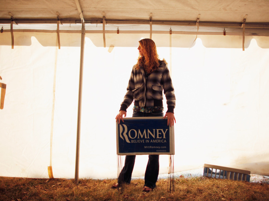 A young Mitt Romney supporter holds yard signs Thursday at a campaign event at J's Homestyle Cooking in Cedar Falls, Iowa.