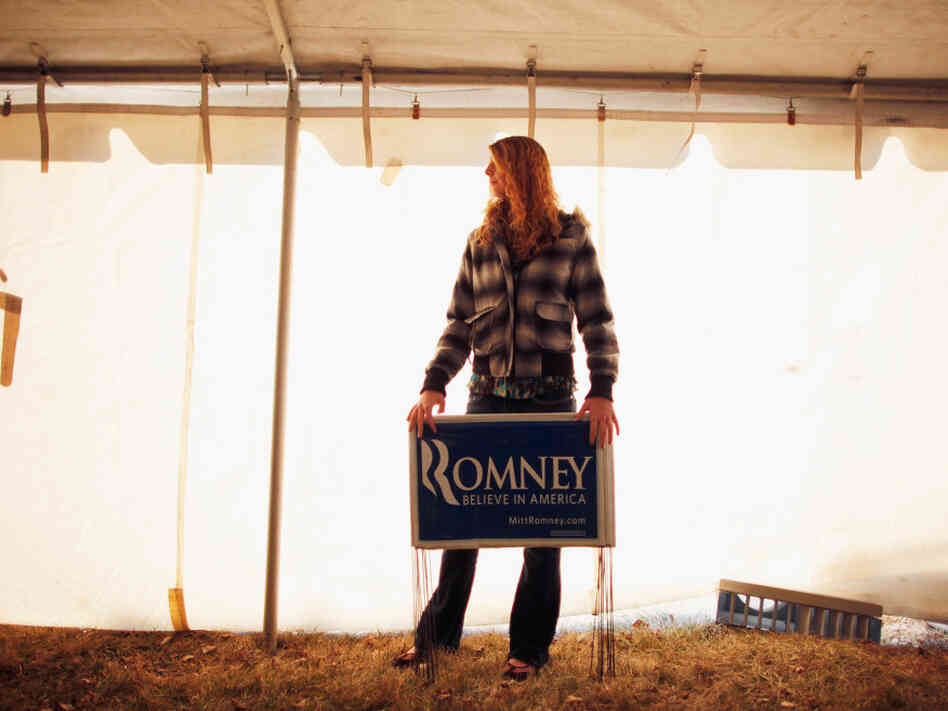 A young Mitt Romney supporter holds yard signs Thursday at a campaign event at J's Homestyle Cooking in Cedar Falls, Iowa.