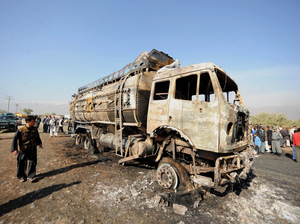 Afghan policemen and locals watch a burned-out fuel truck, supplying a U.S.-run base, after being targeted by a bomb near Bagram Air Field near Kabul on Oct. 26. Attacks on convoys carrying supplies to U.S. troops are costly - both in monetary terms and in human life. Afghan policemen and locals watch a burned-out fuel truck, supplying a U.S.-run base, after being targeted by a bomb near Bagram Air Field near Kabul on Oct. 26. Attacks on convoys carrying supplies to U.S. troops are costly - both in monetary terms and in human life.