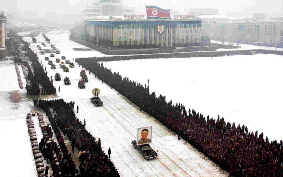 This image, released by the North Korean Central News Agency, was taken within seconds of the one above. An analysis shows that it was digitally altered, removing the cluster of men on the left edge and enhancing the perfect line of mourners.