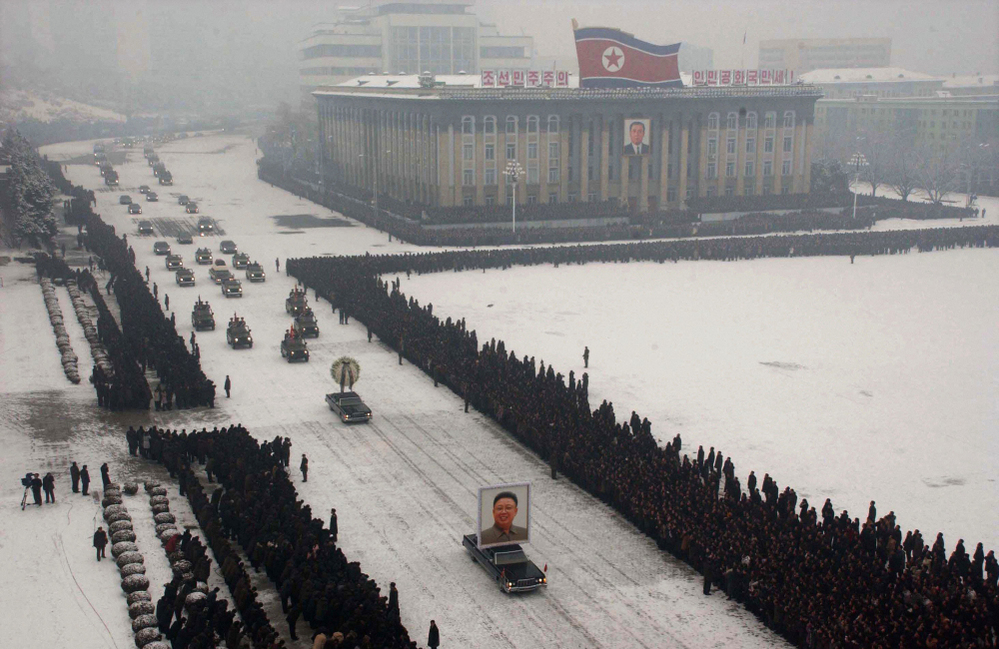 This image, released by Kyodo News and originally transmitted via the Associated Press, shows a cluster of mourners on the left-hand side of the frame.