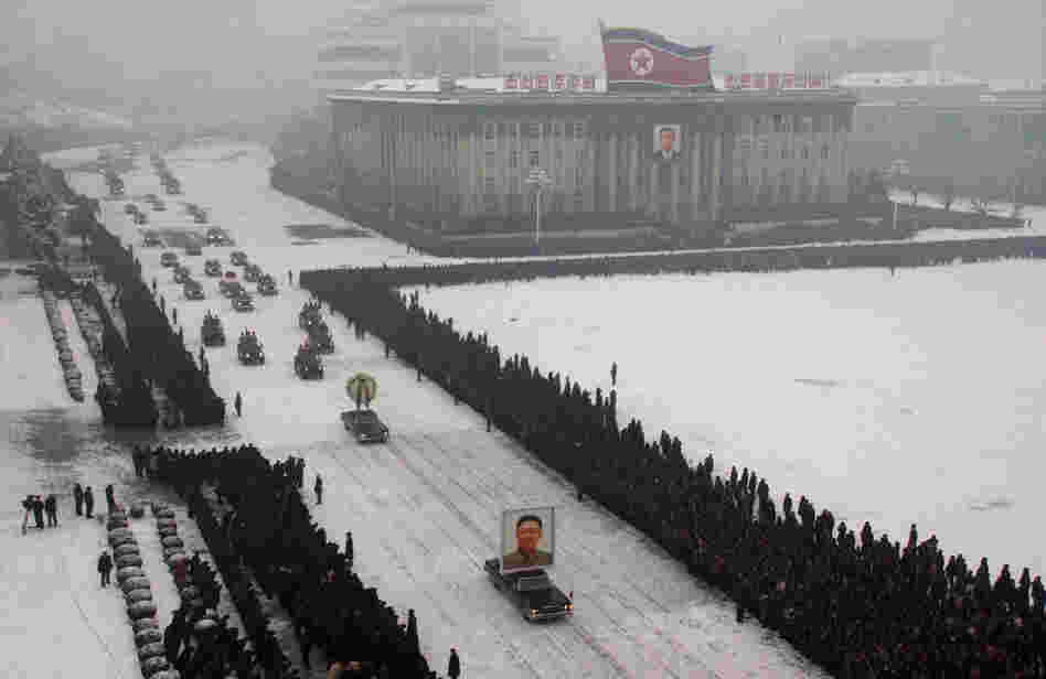 This image, released by Kyodo News and originally transmitted via the Associated Press, shows a cluster of mourners on the left-hand side of the frame.