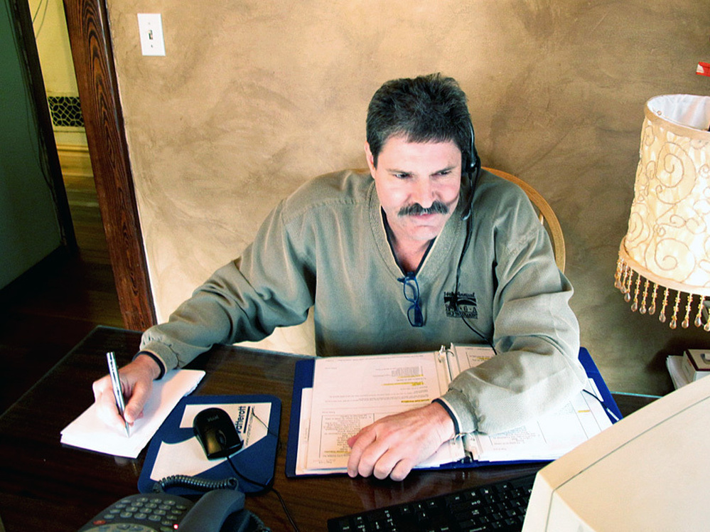 Randy Howland works in his small office in March, shortly after he began a work-from-home job with a call center earning $10 an hour. 