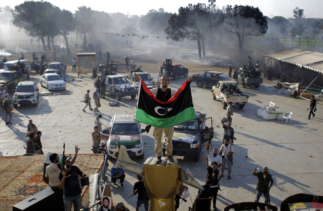 A rebel fighter stands on a monument inside Moammar Gadhafi's main compound in Tripoli.