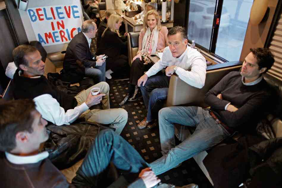 Romney sits with family members and South Dakota Sen. John Thune (second left) on his campaign bus after a rally at in Davenport on Monday. 