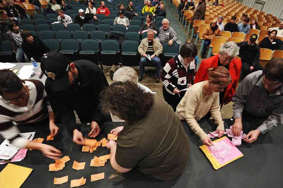 Electoral personnel and volunteers count caucus ballots at a school in Des Moines. 