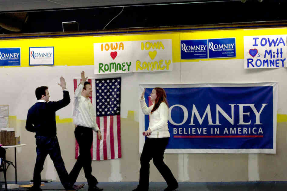 Mitt Romney volunteers throw high-fives at the campaign headquarters in Des Moines, Iowa, after a good event turnout.