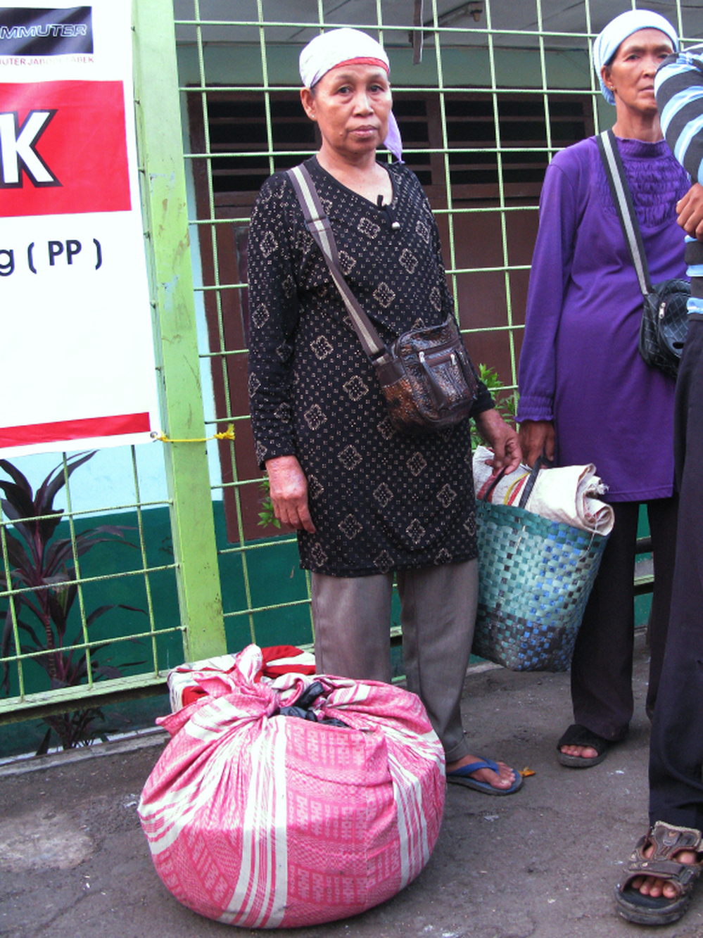 Fruit vendor Mina, who uses just one name, waits for a train home with her merchandise wrapped in a pink cloth.