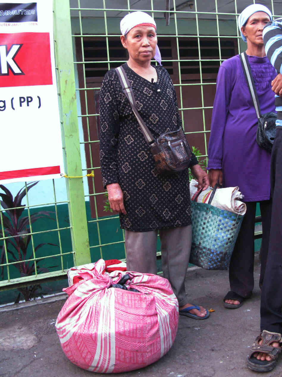 Fruit vendor Mina, who uses just one name, waits for a train home with her merchandise wrapped in a pink cloth.