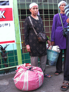 Fruit vendor Mina, who uses just one name, waits for a train home with her merchandise wrapped in a pink cloth. Fruit vendor Mina, who uses just one name, waits for a train home with her merchandise wrapped in a pink cloth.