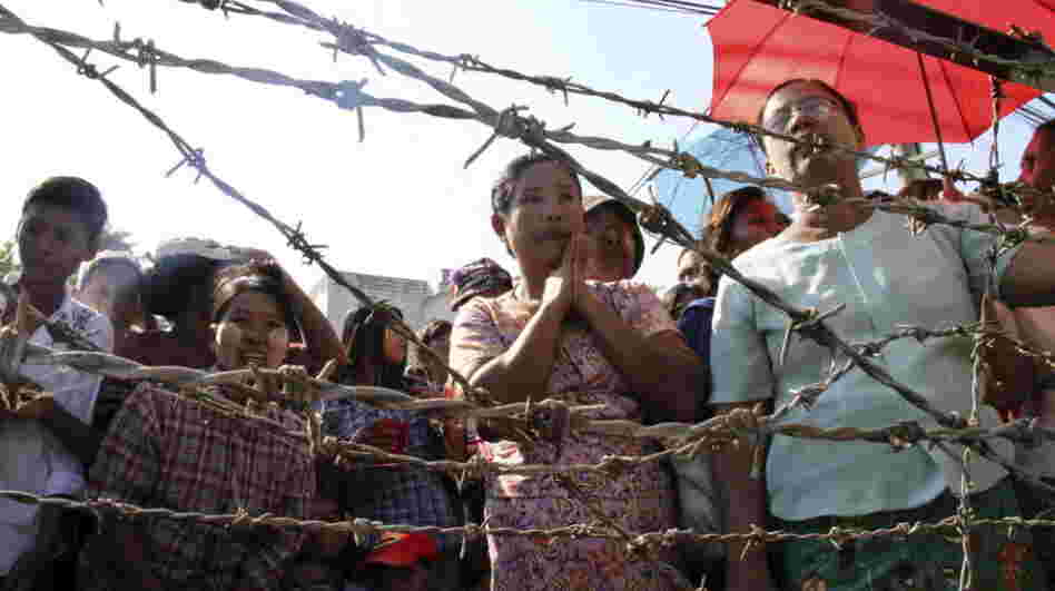 People stand behind barricades as they wait for family members to be freed from Insein Prison in Yangon, Myanmar, on Tuesday. Myanmar's government announced Monday that it is reducing the sentences of many prisoners, but stopped short of declaring an amnesty for political prisoners that many people had expected. People stand behind barricades as they wait for family members to be freed from Insein Prison in Yangon, Myanmar, on Tuesday. Myanmar's government announced Monday that it is reducing the sentences of many prisoners, but stopped short of declaring an amnesty for political prisoners that many people had expected.