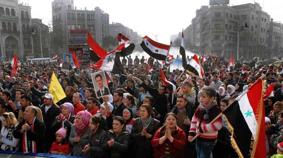 Syria's embattled President Bashar Assad still has supporters, particularly among his fellow Alawites, a minority who believe they will suffer if Assad is ousted. Here, Assad supporters rally Tuesday in the capital, Damascus. Syria's embattled President Bashar Assad still has supporters, particularly among his fellow Alawites, a minority who believe they will suffer if Assad is ousted. Here, Assad supporters rally Tuesday in the capital, Damascus.