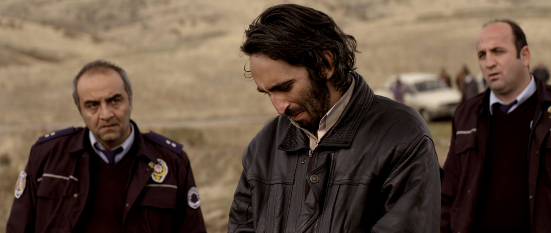 A police commissar (Yilmaz Erdogan, left) and a junior officer (Murat Kilic, right) are among the men shepherding a confessed murderer (Firat Tanis) as he tries to track down the body he's supposedly stashed in the vast landscapes of rural Turkey.