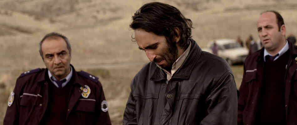 A police commissar (Yilmaz Erdogan, left) and a junior officer (Murat Kilic, right) are among the men shepherding a confessed murderer (Firat Tanis) as he tries to track down the body he's supposedly stashed in the vast landscapes of rural Turkey.