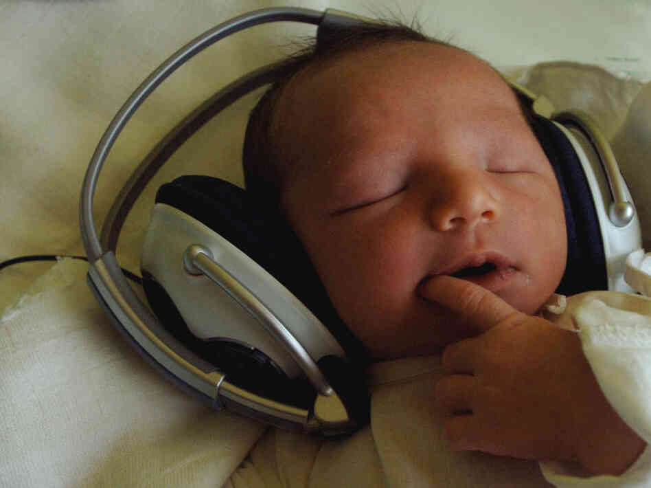 One-day-old Timea listens to music with headphones One-day-old Timea listens to music with headphones