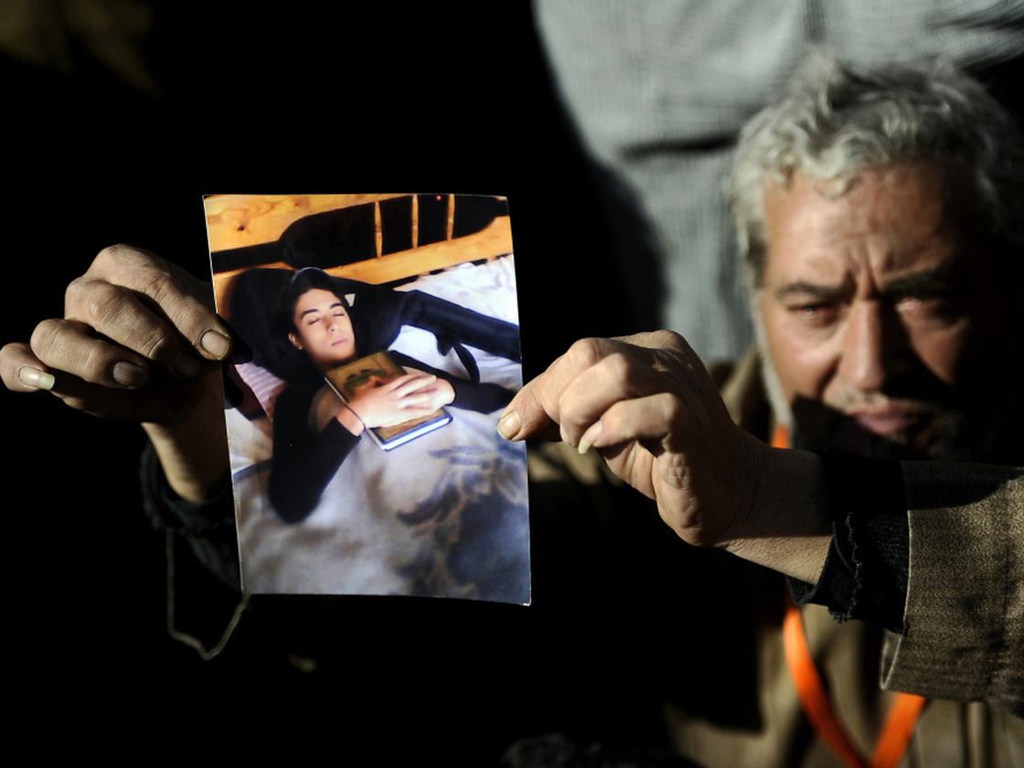 A protester shows a picture of his son, who was killed at a rally in Cairo's Tahrir Square on Dec. 23. Soldiers at the rally were taped beating female protesters, sparking international outrage. Advocates say there has not been similar anger over the deaths of children.