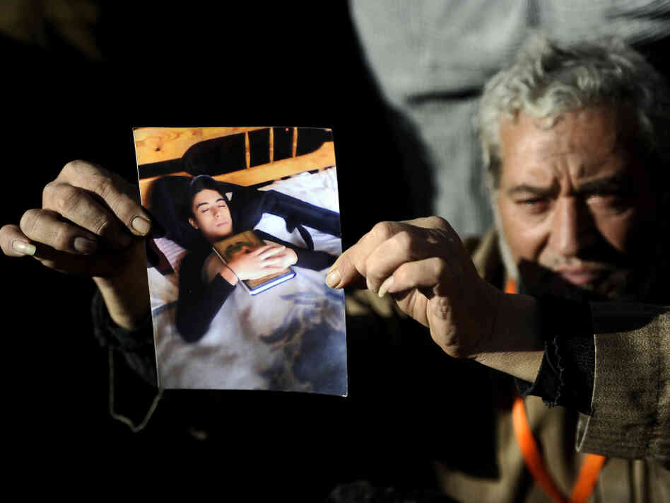 A protester shows a picture of his son, who was killed at a rally in Cairo's Tahrir Square on Dec. 23. Soldiers at the rally were taped beating female protesters, sparking international outrage. Advocates say there has not been similar anger over the deaths of children.