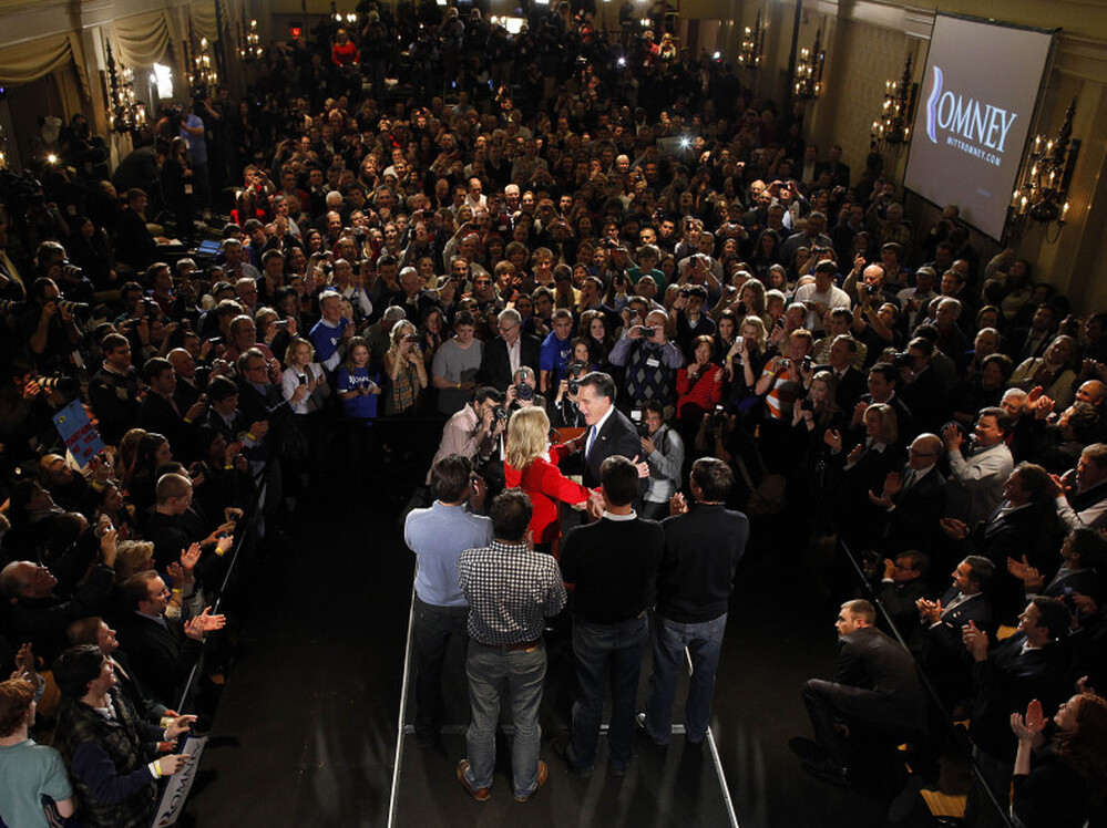 Republican presidential candidate, former Massachusetts Gov. Mitt Romney is the center of attention at rally in Des Moines, Iowa, Tuesday.