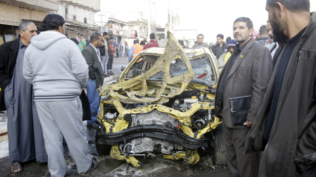 Iraqi men examine some of the wreckage left behind after one of today's explosions in Baghdad.