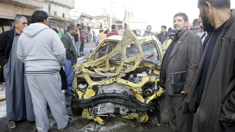 Iraqi men examine some of the wreckage left behind after one of today's explosions in Baghdad. Iraqi men examine some of the wreckage left behind after one of today's explosions in Baghdad.