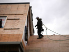 A construction worker walks on the roof of a newly built home in Westport, Conn. The construction sector, which has been battered by the depressed housing sector, added 17,000 jobs in December. A construction worker walks on the roof of a newly built home in Westport, Conn. The construction sector, which has been battered by the depressed housing sector, added 17,000 jobs in December.