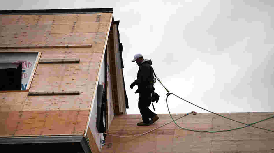 A construction worker walks on the roof of a newly built home in Westport, Conn. The construction sector, which has been battered by the depressed housing sector, added 17,000 jobs in December. A construction worker walks on the roof of a newly built home in Westport, Conn. The construction sector, which has been battered by the depressed housing sector, added 17,000 jobs in December.