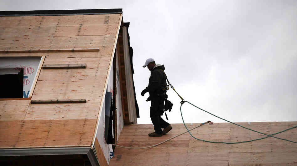 A construction worker walks on the roof of a newly built home in Westport, Conn. The construction sector, which has been battered by the depressed housing sector, added 17,000 jobs in December. A construction worker walks on the roof of a newly built home in Westport, Conn. The construction sector, which has been battered by the depressed housing sector, added 17,000 jobs in December.