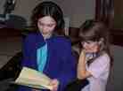 Liza reading her letter to WXXI while her sister Hannah looks on