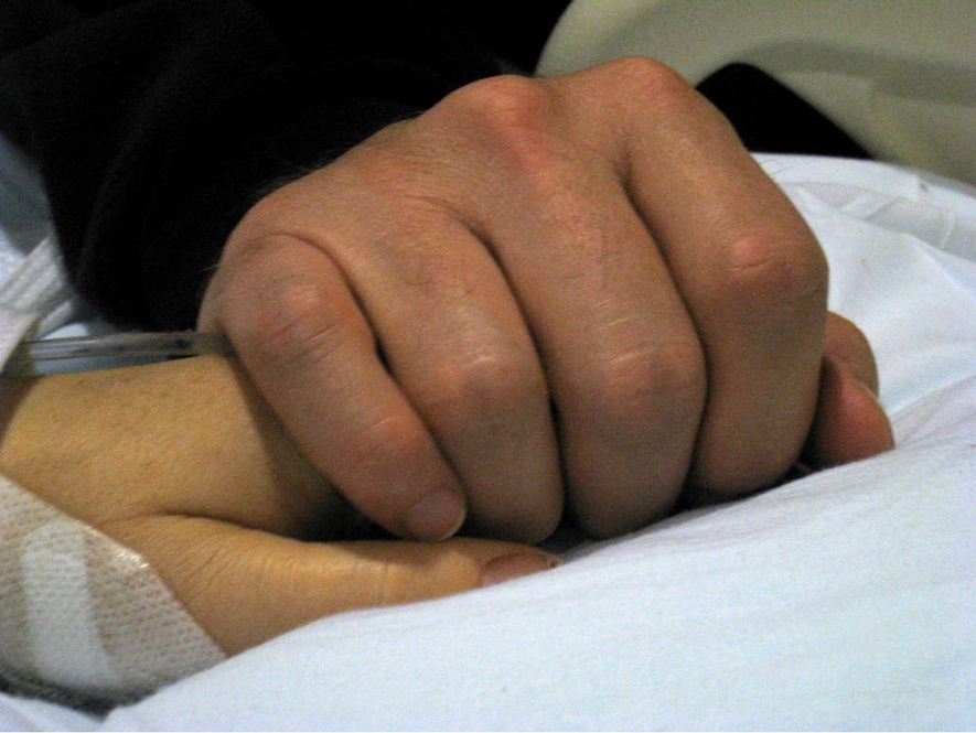 Kelly holds Giffords' hand in her hospital room at University Medical Center in Tucson on Jan. 11. 