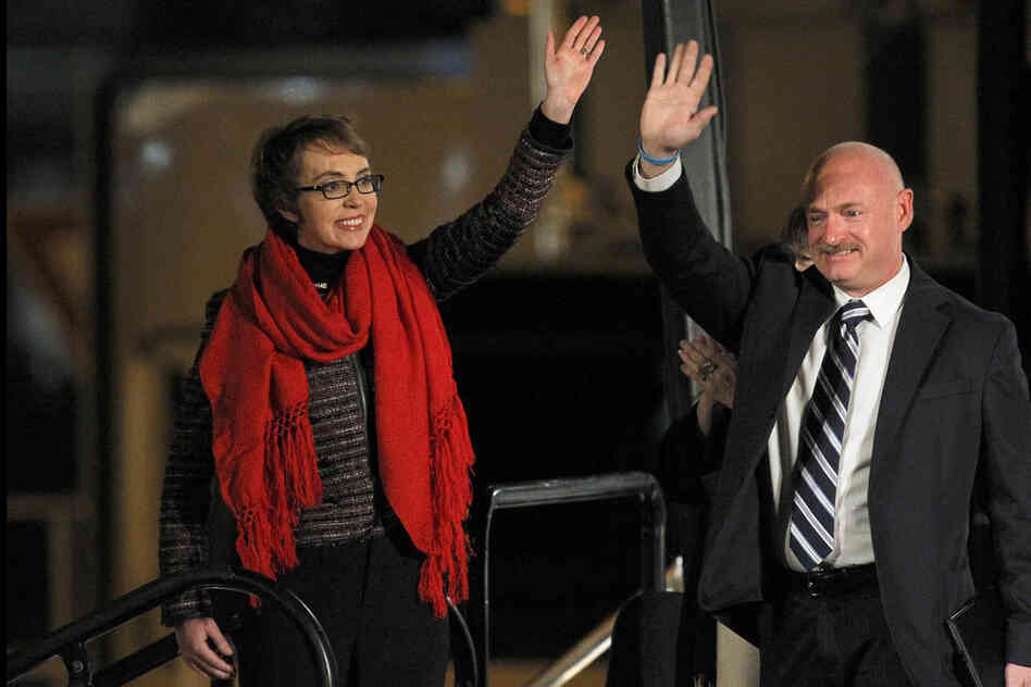 Arizona Rep. Gabrielle Giffords and her husband, Mark Kelly, wave at the start of a memorial in Tuscon, Ariz, on Jan. 8. The vigil marked the anniversary of the shooting rampage that left six dead and 13 injured, including Giffords. 