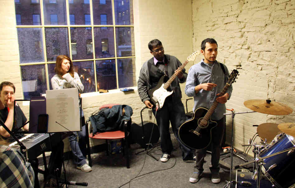Music educator Ivan Trevino (right) leads band practice for M5 Networks employees in Rochester, N.Y., who will play against other branches in a battle of the bands. The telecom company says it wants its employees to learn new things (and stay happy). Music educator Ivan Trevino (right) leads band practice for M5 Networks employees in Rochester, N.Y., who will play against other branches in a battle of the bands. The telecom company says it wants its employees to learn new things (and stay happy).