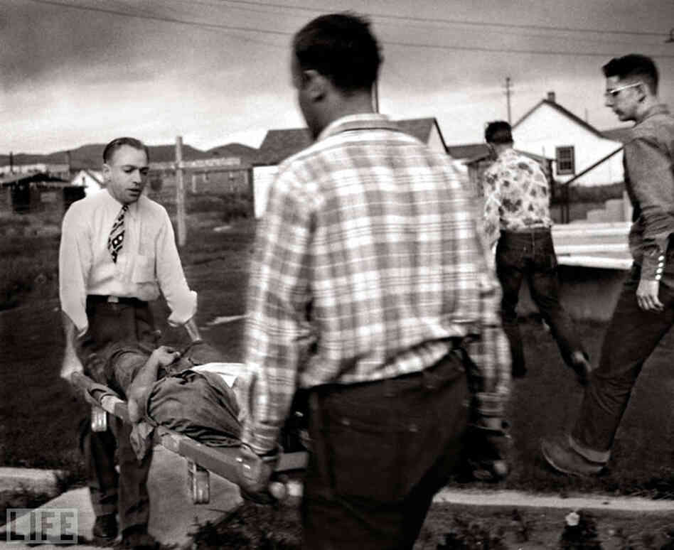 In this image, Dr. Ceriani helps a rancher carry his son into the hospital.