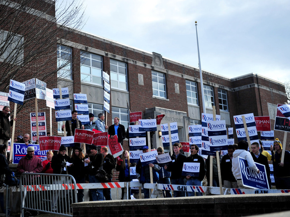 Supporters for various candidates hold signs at the Webster School polling location in Manchester, N.H., on Tuesday. 